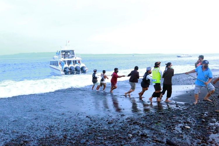 Warga sekitat Pelabuhan Sekarjaya, Klungkung membantu menarik speedboat agar bisa sandar, Jumat (17/4) sore.