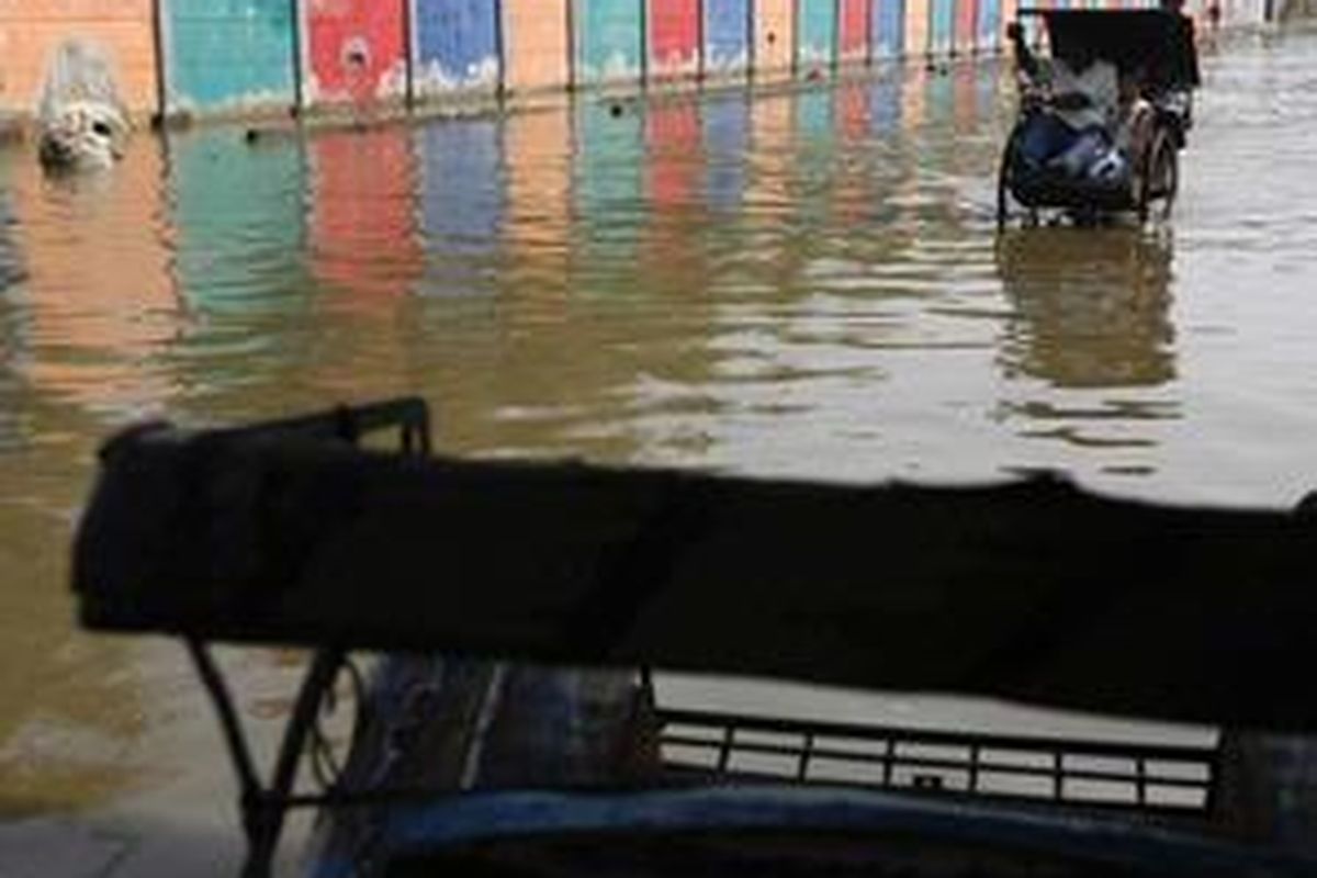 Warga naik becak menembus limpasan air laut di Kelurahan Penjaringan, Kecamatan Penjaringan, Jakarta Utara, Selasa (3/6). Jawatan Hidro-Oseanografi (Janhidros) TNI Angkatan Laut memprakirakan ketinggian puncak air laut pasang pada 4-7 Juni 2008 mencapai maksimum satu meter.