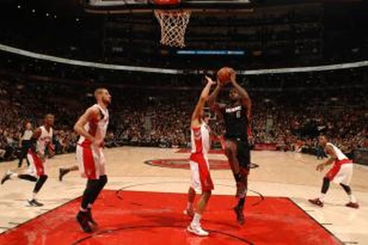 Pebasket Miami Heat, LeBron James (6) bersiap memasukkan bola di dadapan para pemain Toronto Raptors, saat kedua tim bertemu pada laga lanjutan kompetisi NBA, di Air Canada Centre, Toronto, Selasa (5/11/2013).