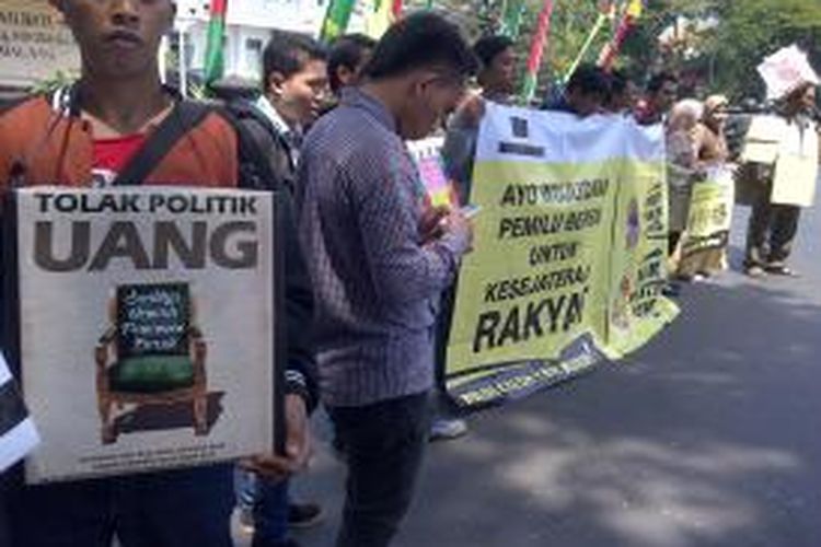 Puluhan warga Malang dan aktivis MCW saat menggelar aksi tolak politik uang jelang pileg di depan Balaikota Malang, Rabu (26/3/2014).