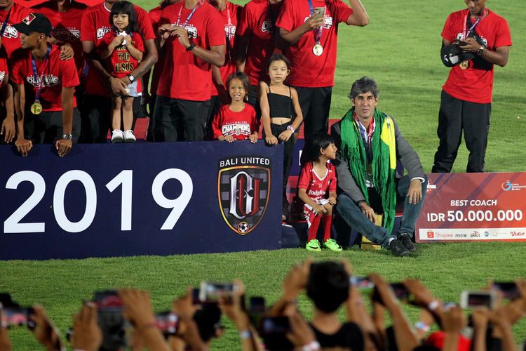 Pelatih Bali United Stefano Cugurra bersama anaknya duduk santai di pinggir podium saat penyerahan tropi juara Liga 1 2019 di Stadion Kapten I Wayan Dipta Gianyar, Bali, Minggu (22/12/2019).