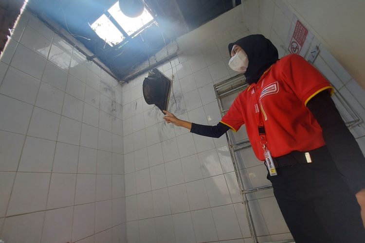 Pegawai minimarket di Bandung Barat menunjuk atap kamar mandi yang dibobol maling, Senin (23/5/2022).
