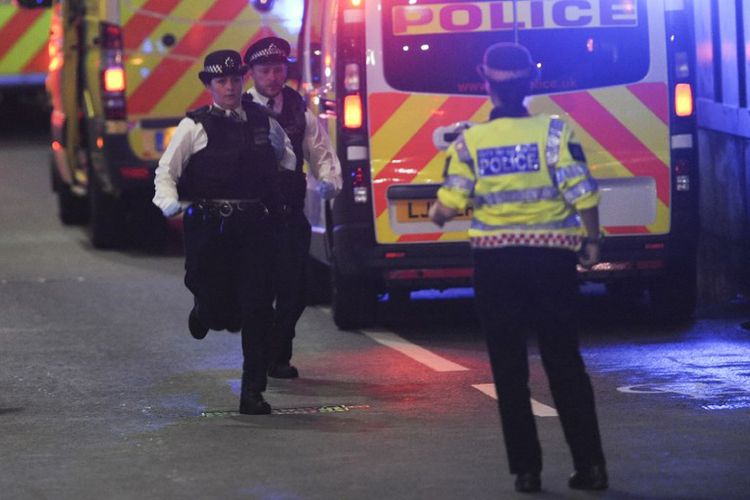 Sejumlah polisi terlihat berlari di sekitar lokasi serangan teror di London Bridge, Sabtu malam (3/6/2017).  