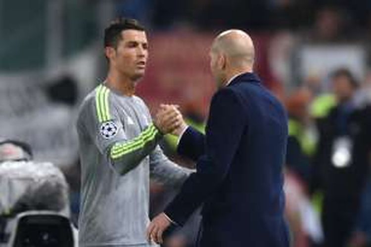 Bintang Real Madrid, Cristiano Ronaldo, menjabat tangan pelatih Zinedine Zidane saat ditarik keluar dalam laga kontra AS Roma pada leg pertama babak 16 besar Liga Champions, Rabu (17/2/2016).