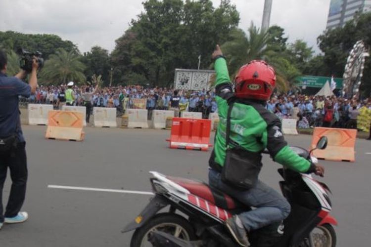 Pengemudi ojek online memprovokasi para sopir taksi yang melakukan aksi demonstrasi di kawasan monas, Jakarta, Selasa (22/3/2016). Para ojek online ini kesal akibat salah satu temannya disweeping dan dipukuli. KOMPAS.com / RODERICK ADRIAN MOZES