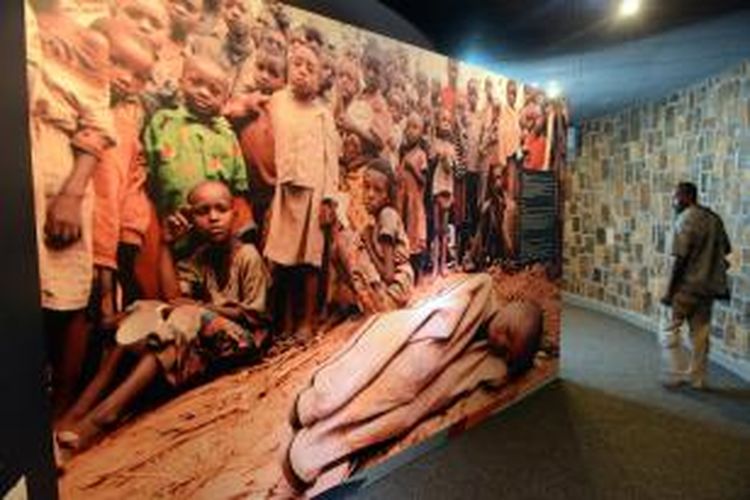 Seorang pria memandang sebuah foto raksasa anak-anak yang menjadi korban genosida Rwanda 20 tahun lalu, di lokasi peringatan genosida di Nyamata, di dalam sebuah gereja Katolik yang pada 1994 menjadi lokasi  pembantaian.