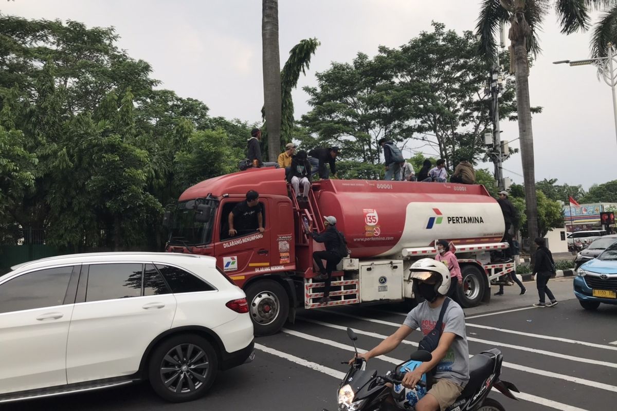 Sejumlah pelajar mencoba naik truk pembawa bahan bakar milik Pertamina yang sedang melintas di Jalan Raya Pondok Indah, Jakarta pada Kamis (8/10/2020) sore.