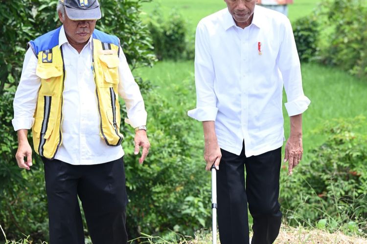 Presiden Joko Widodo ditemani Menteri PUPR Basuki Hadimuljono ketika mengukur lebar jalan menggunakan roda pengukur jalan di Kabupaten Pangkep, Sulawesi Selatan pada Kamis (22/2/2024).