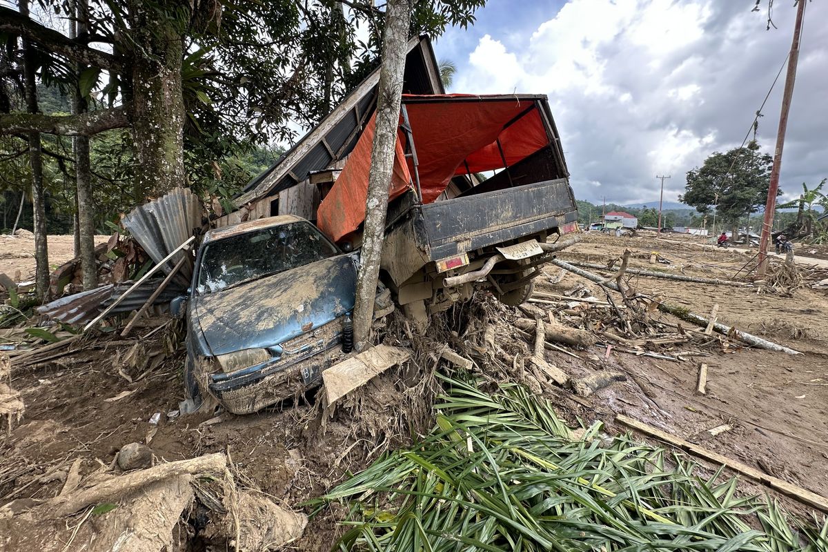 Dua mobil terlihat teronggok rusak akibat banjir bandang di Nagari Salareh Aia Timur, Palembayan, Agam, Sumatera Barat pada Jumat (5/12/2025) siang. Delapan hari pasca-banjir bandang, sejumlah motor dan mobil belum dievakuasi.