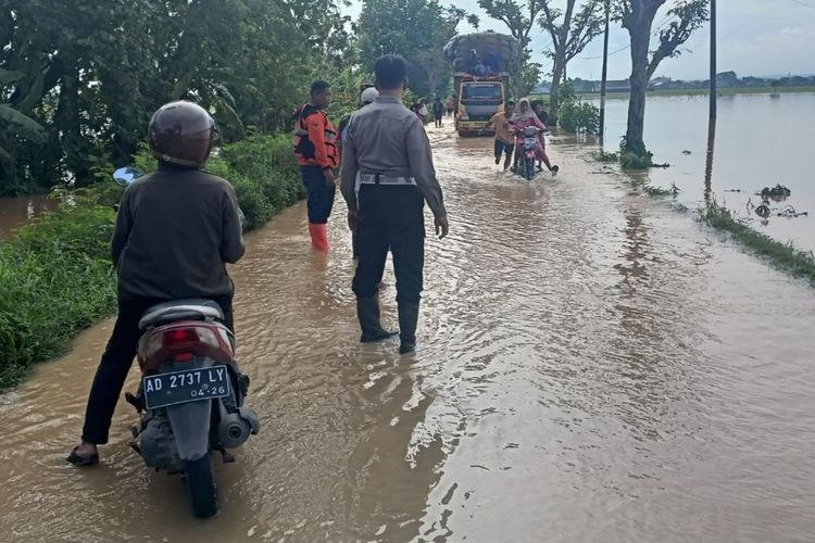 Potret air luapan sungai Bengawan Solo, yang menggenangi area persawahan dan jalan. Kondisi tersebut berdampak pada sulitnya jalan untuk diakses kendaraan.