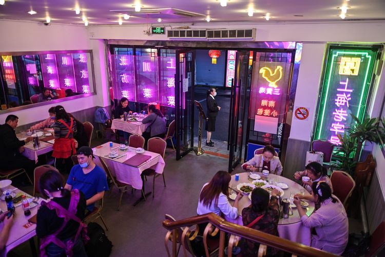 Pengunjung menikmati makanan di sebuah restoran di Shanghai, 1 Mei 2020. Setelah sempat menjalani masa karantina akibat penyebaran Covid-19, jutaan warga China kembali turun ke jalan dan mengunjungi kawasan wisata yang kembali dibuka.