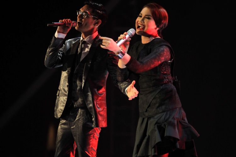 Penyanyi Afgan Syahreza berkolaborasi dengan Rossa menghibur penonton saat Konser Dari Hati di Jakarta Convention Center, Sabtu (14/2/2014). Konser yang bertepatan dengan Hari Valentine ini ia berkolaborasi dengan Rossa, Sherina Munaf, dan DJ Dipha Barus. KOMPAS IMAGES/KRISTIANTO PURNOMO