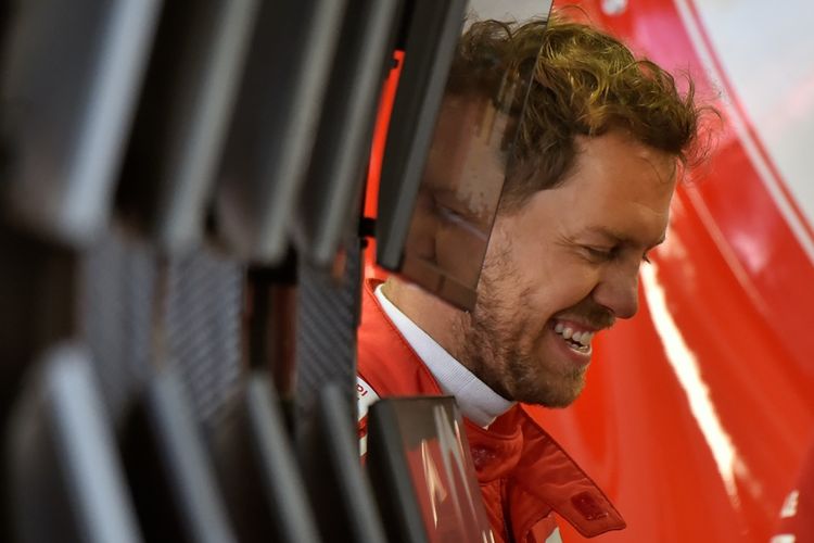 Pebalap Ferrari asal Jerman, Sebastian Vettel, bercanda dengan kru di garasi Sochi Autodrom pada hari pertama GP Rusia, Jumat (28/4/2017).