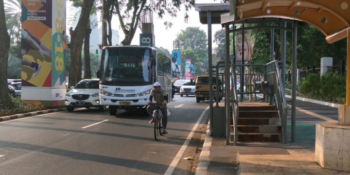 Seorang pesepeda bersepeda di ruas Jalan Asia Afrika, Senayan, Jakarta, Selasa (31/7/2018). Dia tidak menggunakan jalur sepeda di trotoar. Di sisi lain, jalur sepeda di trotoar itu juga terhalang tiang.