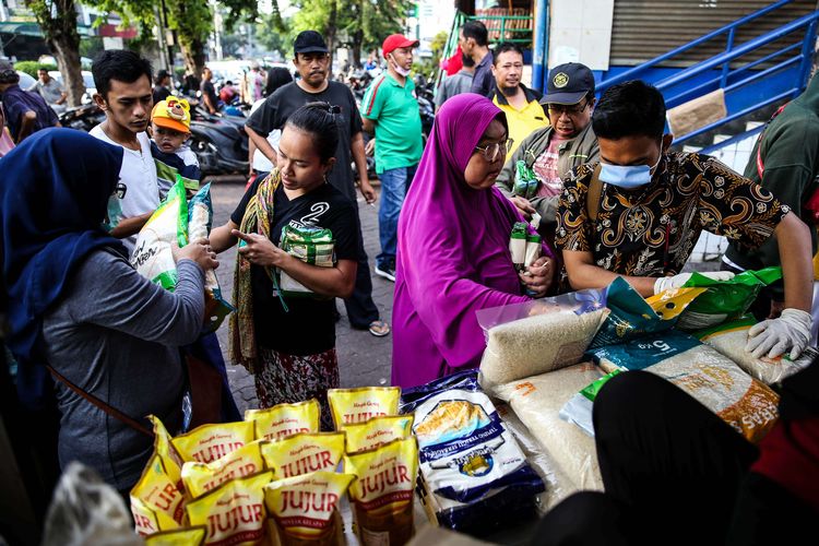 Warga membeli bahan pokok berupa minyak dan beras saat operasi pasar stok pangan di Pasar Rawamangun, Jakarta Timur, Kamis (19/3/2020). Perum Bulog bekerja sama dengan Sugar Group Companies menggelar kegiatan operasi pasar pangan dalam rangka menjamin ketersediaan bahan pangan pokok, serta menjaga stabilitas harga ditengah kekhawatiran masyarakat akibat pandemi virus Corona atau Covid-19. Operasi pasar stok pangan akan berlangsung selama seminggu di beberapa pasar untuk wilayah DKI Jakarta dan Banten.