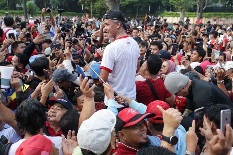 Gubernur Jawa Tengah sekaligus bakal calon presiden yang diusung Partai Demokrasi Indonesia Perjuangan, Ganjar Pranowo menyapa simpatisan saat lari pagi di kawasan Stadion Gelora Bung Karno, Jakarta, Minggu (30/4/2023).