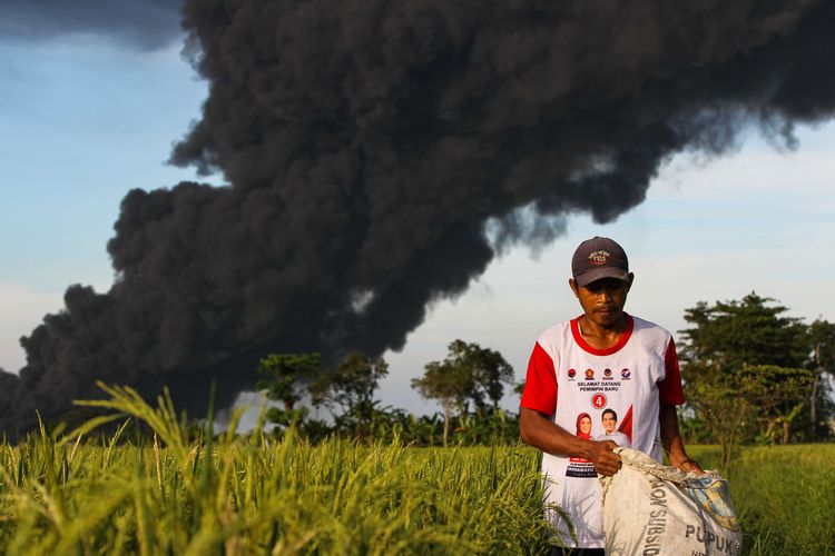 Asap membubung tinggi akibat kebakaran kilang minyak milik Pertamina RU VI di Balongan, Indramayu, Jawa Barat, Senin (29/3/2021).  Tangki di kilang minyak milik Pertamina ini terbakar pada Senin, pukul 00.45 WIB.