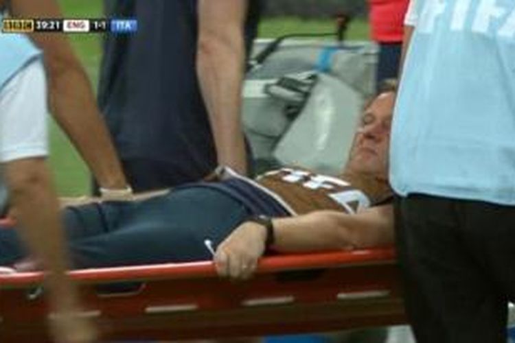 Staf medis Inggris, Gary Lewin, digotong keluar meninggalkan lapangan karena cedera saat melakukan selebrasi gol pada laga Inggris melawan Italia di Arena Amazonia, Manaus, Sabtu (14/6/2014).