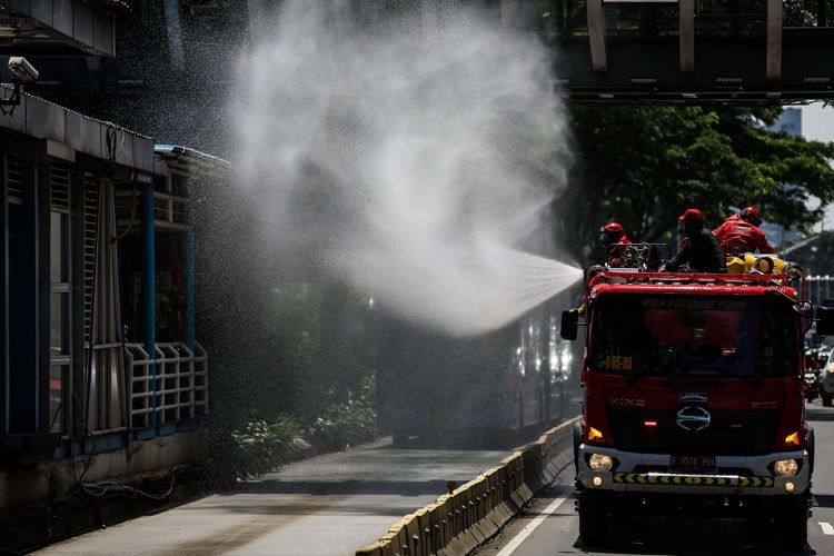 Petugas Pemadam Kebakaran (Damkar) menyemprotkan disinfektan di sepanjang jalan protokol dari monas sampai bunderan senayan di Jakarta, Selasa (31/3/2020). Penyemprotan disinfektan dalam rangka mitigasi pencegahan virus corona (COVID-19).(KOMPAS.com/GARRY LOTULUNG)


