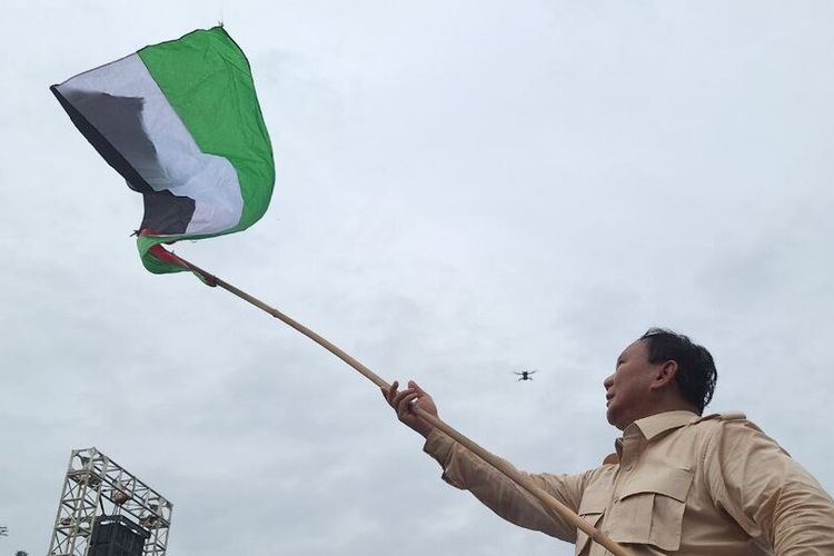 Prabowo Subianto mengibarkan bendera Palestina saat berkampanye di Batam, Kepulauan Riau, Sabtu (13/1/2024).