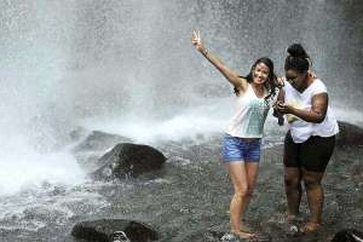 Wisatawan mengunjungi air terjun Sendang Gile di kaki Gunung Rinjani, Desa Senaru, Kecamatan Bayan, Lombok Utara, Nusa Tenggara Barat, Rabu (27/1/2016). Sendang Gile menjadi salah satu situs geologi Gunung Rinjani yang mendukung dijadikannya Gunung Rinjani sebagai taman bumi (geopark) dunia. 