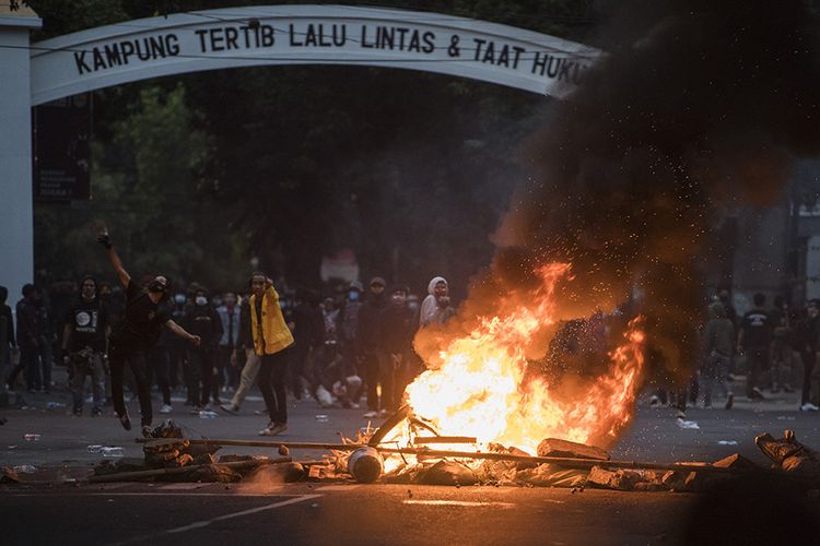 Demonstran melempar batu saat unjuk rasa di Bandung, Jawa Barat, Rabu (7/10/2020). Unjuk rasa menolak UU Cipta Kerja tersebut berakhir ricuh.