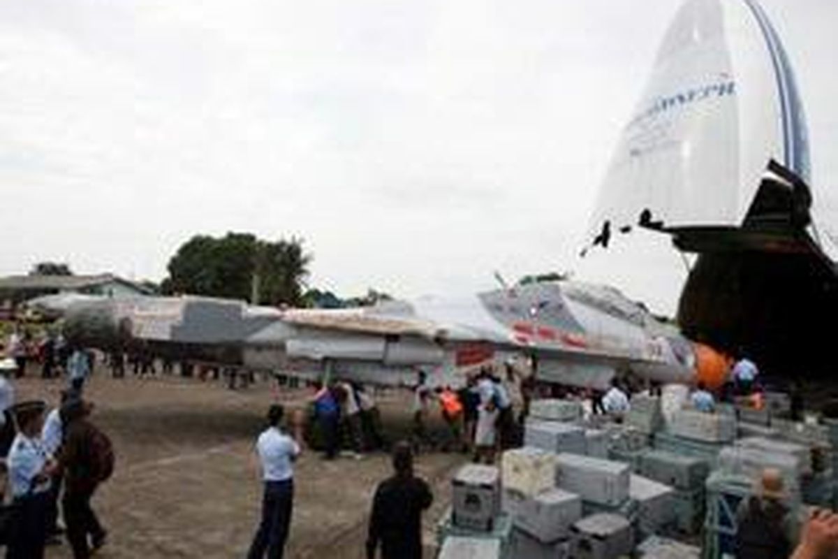 Anggota TNI AU menurunkan pesawat tempur Sukhoi buatan Rusia dari dalam pesawat Anthonov saat tiba di Bandara Hasanuddin, Makassar, Jumat (26/12). Dua pesawat yang dibeli pemerintah Indonesia yakni Sukhoi SU 30 MK2 dan SU 27 SKM diangkut pesawat Anthonov AH 124-100 langsung dari Rusia.