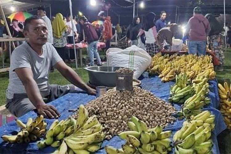 Seorang penjual kacang dan pisang di Lapangan Porbat Batudaa pada tradisi hui lo kunu atau malam kunut saat pertengahan Ramadhan, Selasa (26/3/2024). Tradisi ini turun-temurun dari awal abad 20 di Desa Payunga Kecamatan Batudaa Kabupaten Gorontalo.