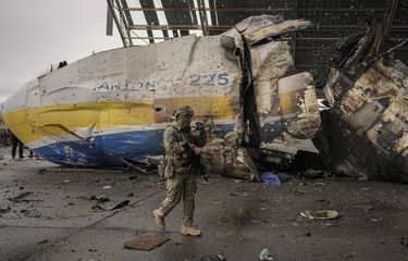 Seorang tentara Ukraina berjalan di depan bagian pesawat Antonov An-225 Mriya yang hancur dalam pertempuran Rusia vs Ukraina di bandara Hostomel, Ukraina, Sabtu (2/4/2022).