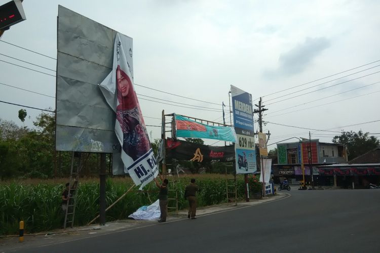 Petugas Gabungan dari Bawaslu dan Satpol PP Gunungkidul menurunkan Alat Peraga Kampanye (APK) di Sekitar Kota Wonosari Kamis (20/9/2018)