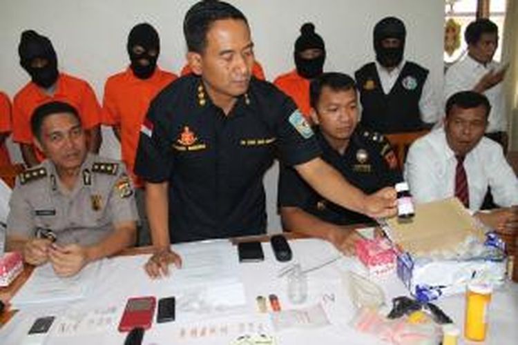 Direktur Reserse Narkoba Kepolisian Daerah (Polda) NTT, Kombes Kumbul KS (sedang menunjukan obat terapi untuk pecandu narkoba jenis Methadone), dan Plt Kepala Kantor Bea dan Cukai Kupang, Suprapto (Kanan), yang didampingi Kepala Bisa Hubungan Masyarakat Polda NTT, AKBP Jules Abraham Abast (kiri), saat menggelar konferensi pers di Markas Polda NTT, Senin (19/10/2015) siang.