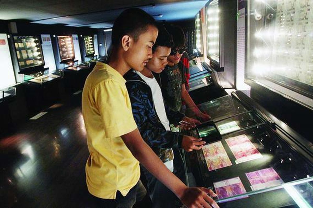 Pengunjung memperhatikan mata uang kertas yang dipamerkan di Museum Bank Indonesia, Kawasan Kota Tua, Jakarta Barat. Mengunjungi museum pada malam hari selain menyenangkan, juga merasakan sensasi tersendiri bisa menghilangkan kesan angker di museum itu sendiri.