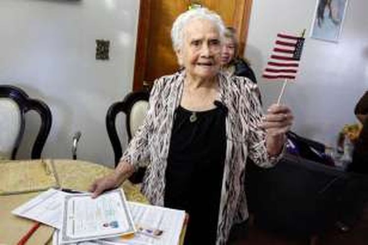 America Maria Hernandez, mengibarkan bendera kecil Amerika Serikat, setelah resmi menandatangani sertifikat naturalisasi, di New York, Rabu (23/11/2016).  