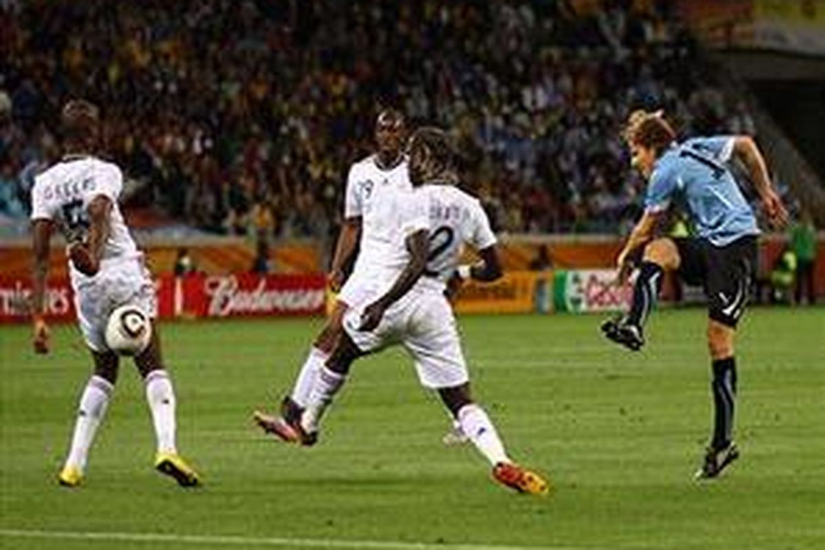 Penyerang Uruguay, Diego Forlan (kanan), melepaskan tembakan akurat yang nyaris merobek gawang Perancis, pada babak pertama duel penyisihan Grup A, Jumat (11/6/2010).