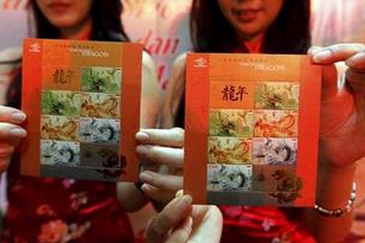 Model menunjukkan perangko seri terbaru bertemakan Naga Air, di Main Atrium East Mall, Grand Indonesia Shoping Center, Jakarta, Selasa (17/1/2012). Perangko seri terbaru hasil kerjasama PT Pos Indonesia dan Lembaga Kerjasama Ekonomi, Sosial dan Budaya Indonesia-China ini, diluncurkan dalam rangka merayakan Tahun Baru China.