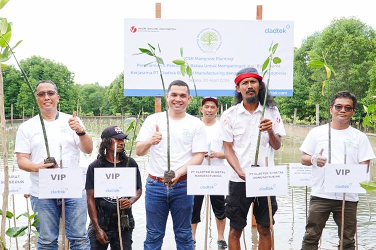 Terlihat para relawan yang merupakan para karyawan Cladtek berfoto bersama menunjukkan benih mangrove yang mereka tanam dalam kegiatan Penanaman Mangrove dan Pembersihan Area di Hutan Lindung Sei Beduk, Batam, Kepulauan Riau (Kepri), Selasa (30/4/2024).