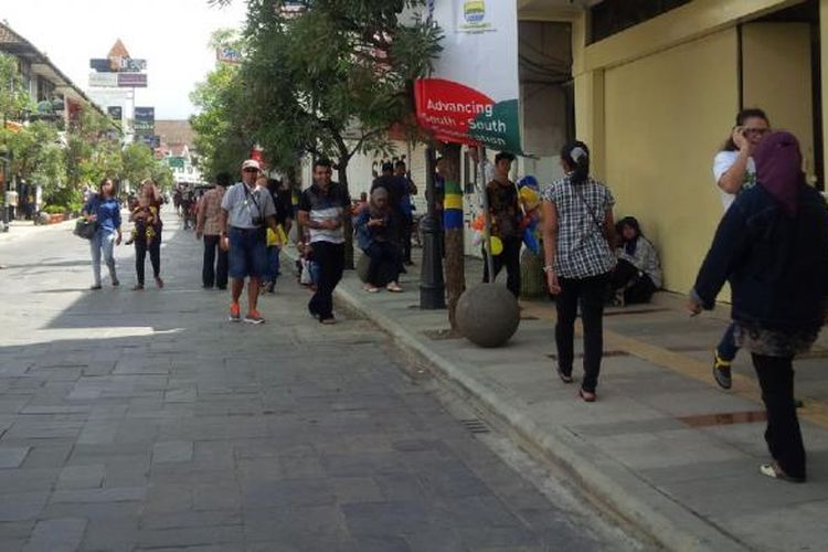 Wisatawan lokal dan asing sedang menikmati Braga di pagi hari dengan jalan kaki.