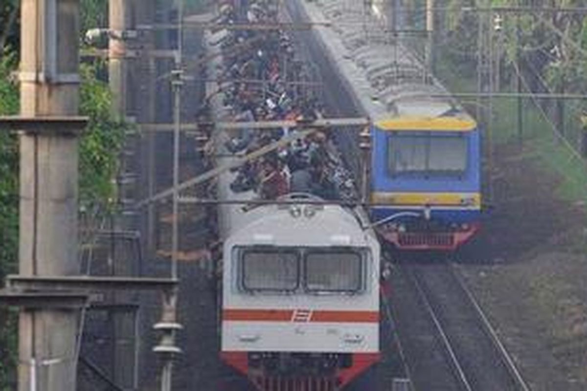 Penumpang memadati atap gerbong kereta rel listrik (KRL) ekonomi Bogor-Jakarta yang melintas di kawasan Tanjung Barat, Pasar Minggu, Jakarta Selatan, Selasa (26/3/2013).