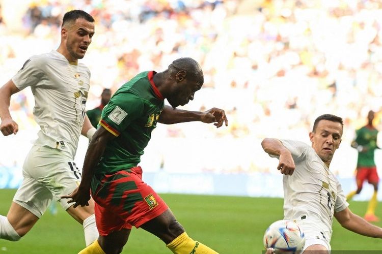 Penyerang Kamerun Christian Bassogog (hijau) berebut bola dengan gelandang Serbia Nemanja Maksimovic pada laga Grup G Piala Dunia 2022 Qatar antara Kamerun vs Serbia di Stadion Al-Janoub di Al-Wakrah, selatan Doha pada Senin 28 November 2022.