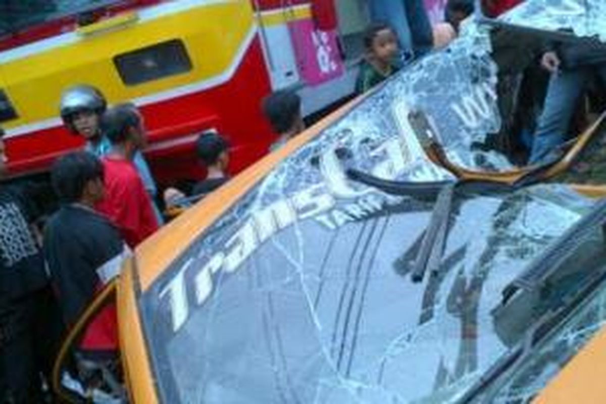 Taksi berwarna kuning ditabrak KRL Commuter Line di pintu perlintasan Cipinang, Jakarta Timur, Rabu(6/11/2013). 