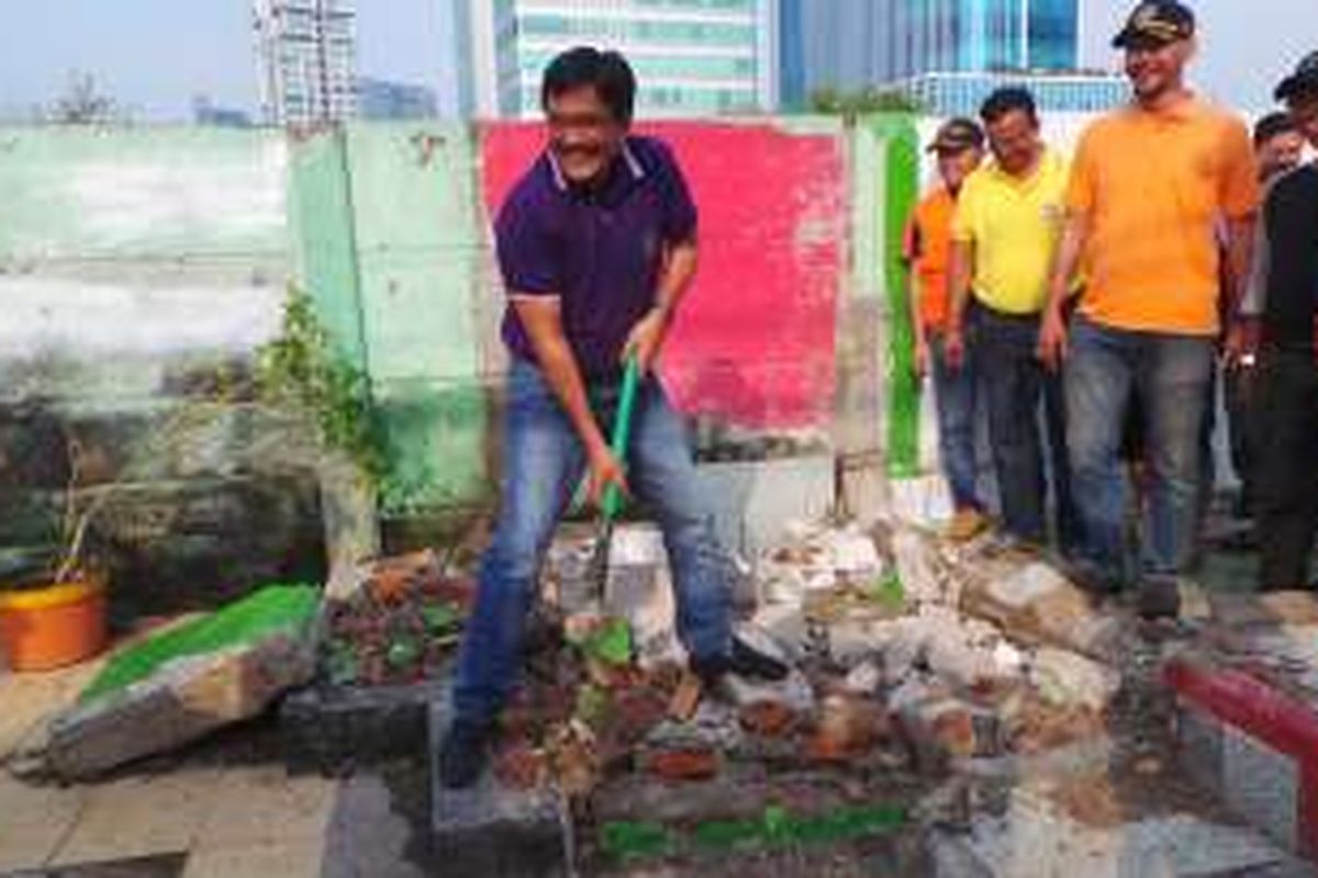 Wakil Gubernur DKI Jakarta Djarot Saiful Hidayat (pakai polo ungu) saat membersihkan toilet bekas gusuran bersama anggota DPRD DKI Jakarta Ashraf Ali (pakai kaos kuning) di Pasar Manggis, Jakarta Selatan, Minggu (17/7/2016).