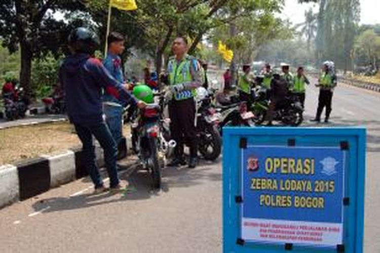 Petugas lalu lintas Polres Bogor menindak pengendara bermotor yang melanggar berlalu lintas di Jalan Raya Tegar Beriman, Ciibinong, Kabupaten Bogor, Kamis (22/10/2015). K97-14