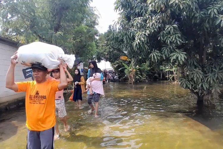 Warga Desa Wonoketingal, Kecamatan Karanganyar nampak hilir mudik menengok kondisi rumah setelah tergenang banjir lebih dari sepekan, Sabtu (17/2/2024). (KOMPAS.COM/NUR ZAIDI)