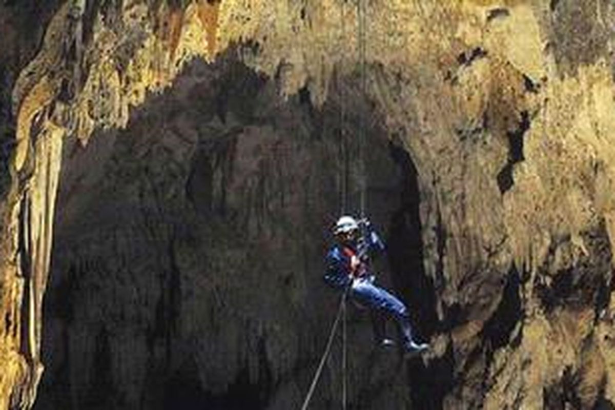 Pemanjat tebing memasuki goa vertikal Luweng Cokro yang memiliki kedalaman sekitar 35 meter dari permukaan tanah di Dusun Blimbing, Desa Umbulrejo, Ponjong, Gunung Kidul, DI Yogyakarta, Selasa (21/6).