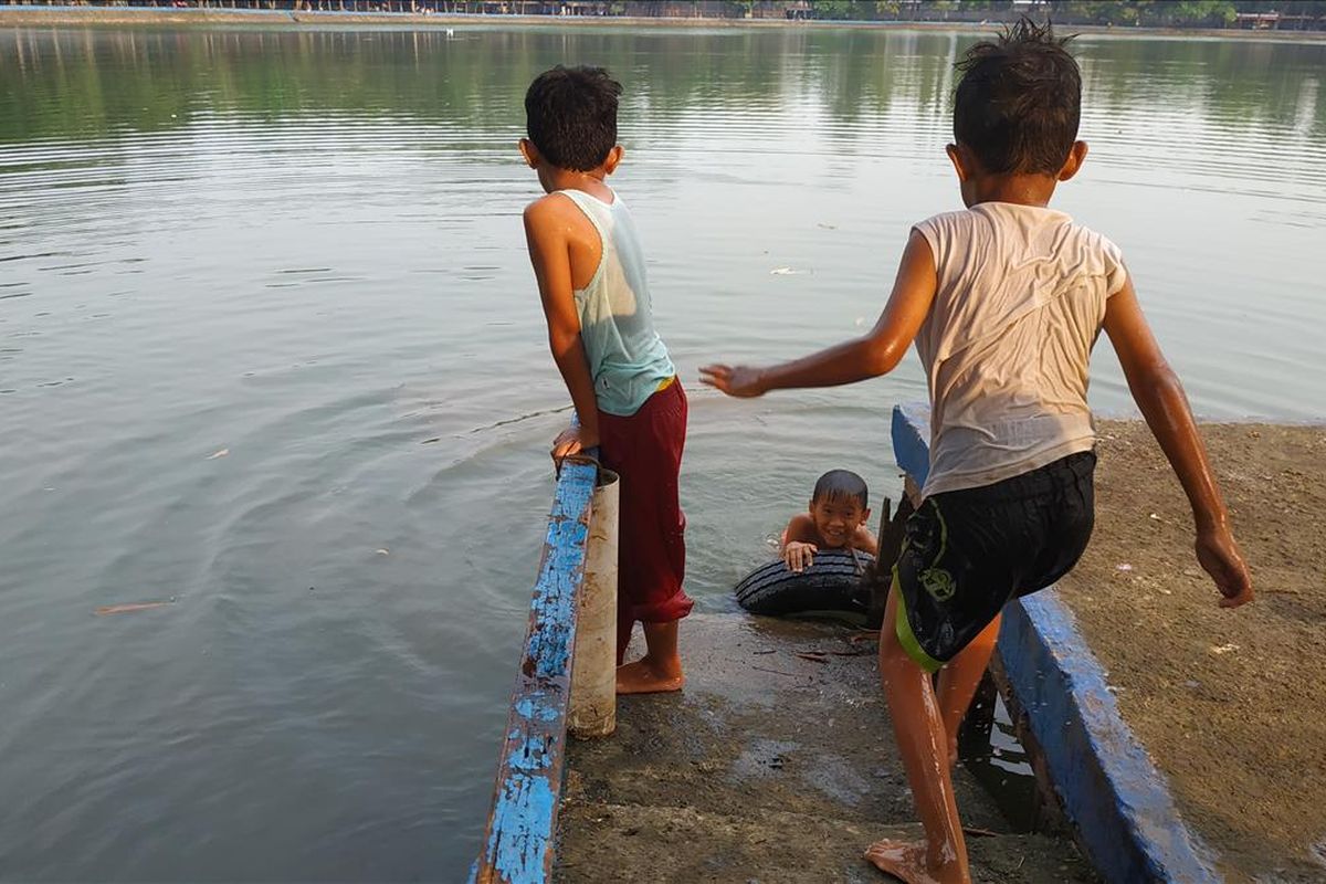 Anak-anak kecil bermain air di Setu Babakan, Jakarta Selatan, Jumat (17/5/2019).