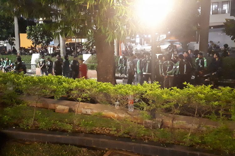 Sekitar 100 pendemo yang memilih untuk bertahan menunggu perwakilan Grab Indonesia. Mereka duduk di sepanjang trotoar depan Gedung Lippo Kuningan, Rabu (19/9/2018).