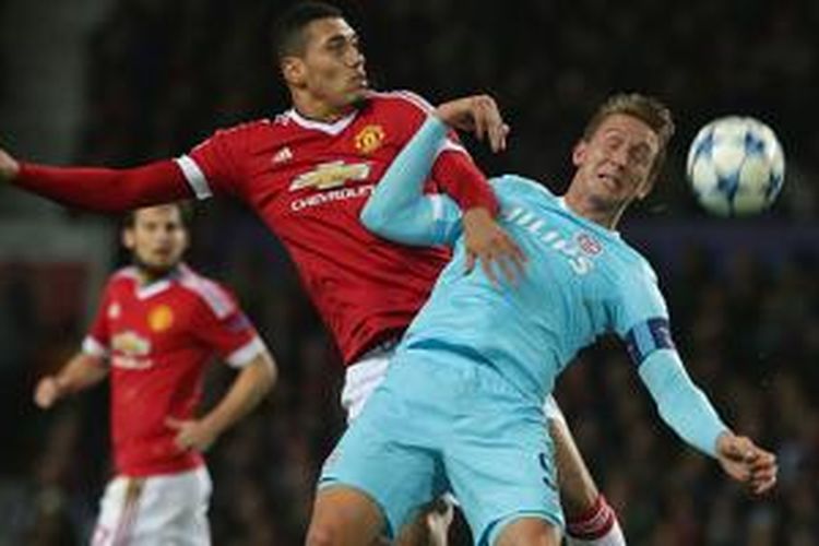 Chris Smalling berduel dengan Luuk de Jong saat Manchester United bermain imbang 0-0 melawan PSV Eindhoven di Stadion Old Trafford, Rabu (25/11/2015). 