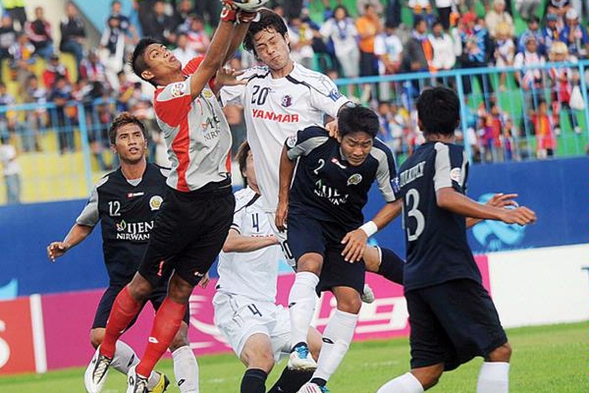 Penjaga gawang Arema Indonesia, Kurnia Meiga (kiri), mempertahankan daerahnya dari serangan pemain Cerezo Osaka Jepang, Takahashi Daisuke, dalam laga Liga Champions Asia di Stadion Kanjuruhan, Kabupaten Malang, Jawa Timur, Selasa (3/5). Arema  kalah 0-4.