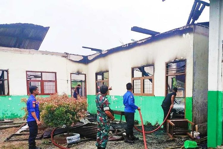 Petugas gabungan memadamkan api kebakaran SMP Muhammadiyah di Desa Suka Damai, Kecamatan Ujung Batu, Kabupaten Rokan Hulu, Riau, Jumat (5/8/2022).