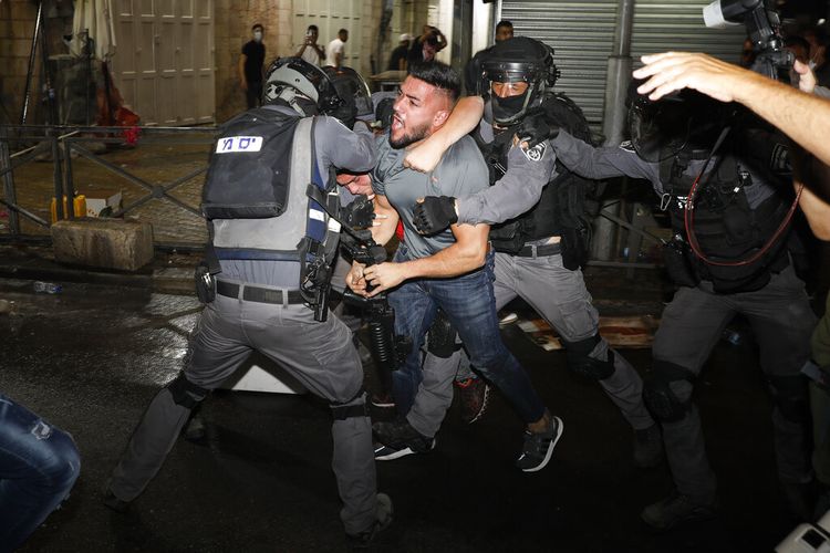 Petugas polisi Israel bentrok dengan pengunjuk rasa Palestina di dekat Gerbang Damaskus tepat di luar Kota Tua Yerusalem, Minggu (9/5/2021) malam waktu setempat.